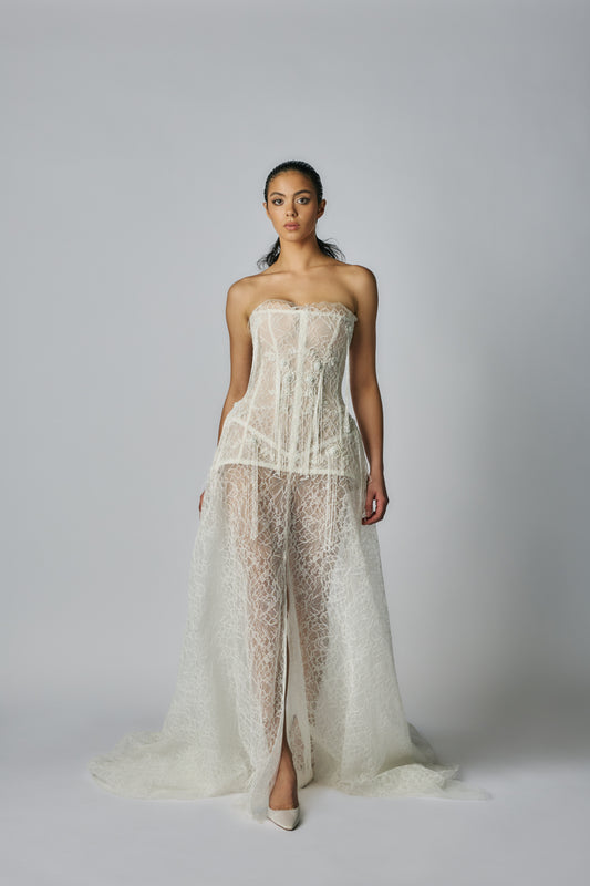 Woman wearing a strapless lace dress on a plain background